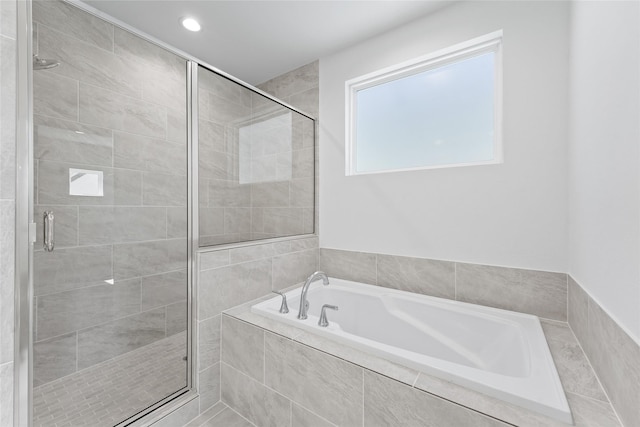bathroom with a shower stall and a bath