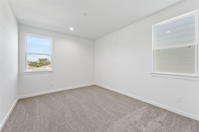empty room featuring recessed lighting, carpet floors, and baseboards
