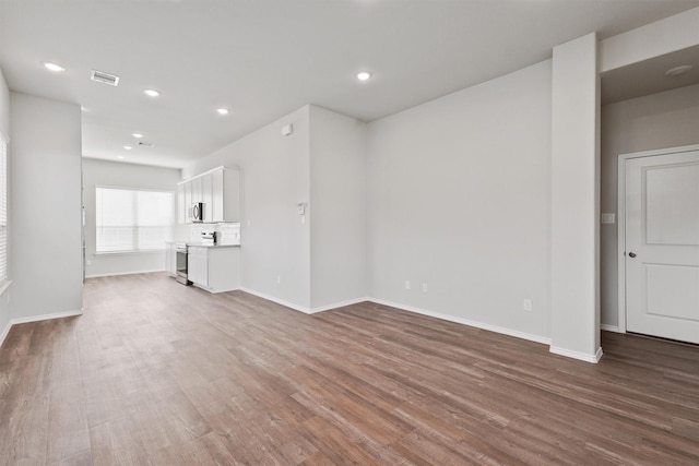2116 Cedar Bend Dr, Conroe, TX 77306 - unfurnished living room with baseboards, wood finished floors, visible vents, and recessed lighting