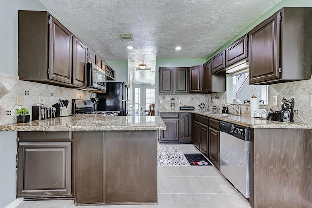 1410 Quiet Green Ct, Houston, TX 77062 - kitchen featuring stainless steel appliances, dark brown cabinets, visible vents, decorative backsplash, and a peninsula