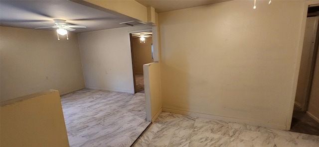 unfurnished room featuring a ceiling fan, baseboards, and marble finish floor