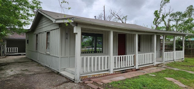 view of side of property featuring board and batten siding and covered porch