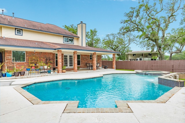 view of swimming pool featuring a patio area, french doors, fence, a fenced in pool, and an in ground hot tub