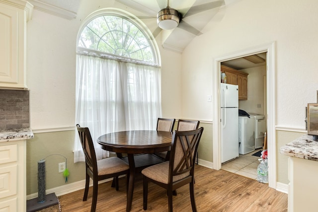 dining area featuring light wood-style floors, washing machine and clothes dryer, and ceiling fan