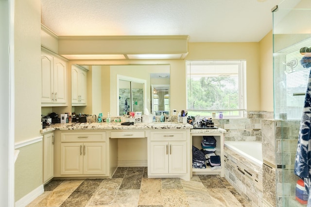 bathroom with stone tile floors, a garden tub, vanity, and a stall shower