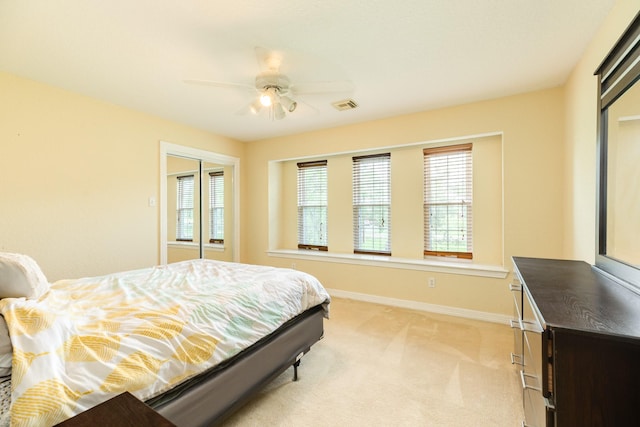 bedroom with baseboards, light carpet, visible vents, and ceiling fan
