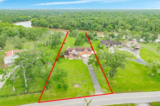 birds eye view of property featuring a wooded view and a water view