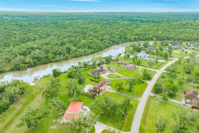 drone / aerial view with a wooded view and a water view