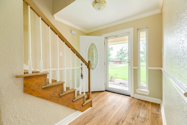 entryway featuring baseboards, wood finished floors, stairway, and crown molding