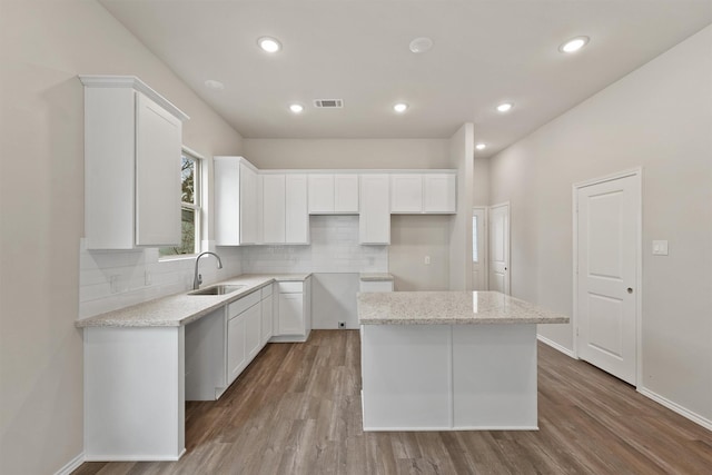 8685 Sassafras St, Willis, TX 77318 - kitchen featuring a sink, visible vents, backsplash, white cabinetry, and wood finished floors