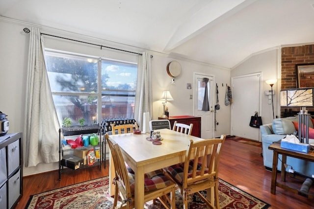 dining space featuring vaulted ceiling and wood finished floors