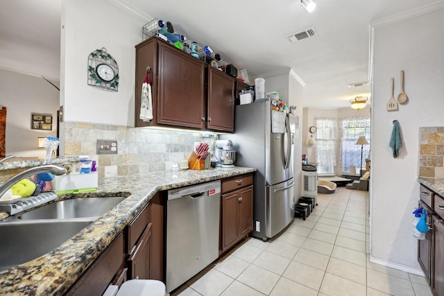 kitchen with stainless steel appliances, a sink, visible vents, backsplash, and ornamental molding
