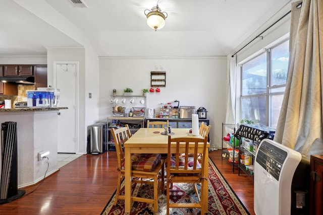 dining area featuring wood finished floors and ornamental molding