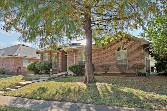 ranch-style house featuring brick siding and a front yard