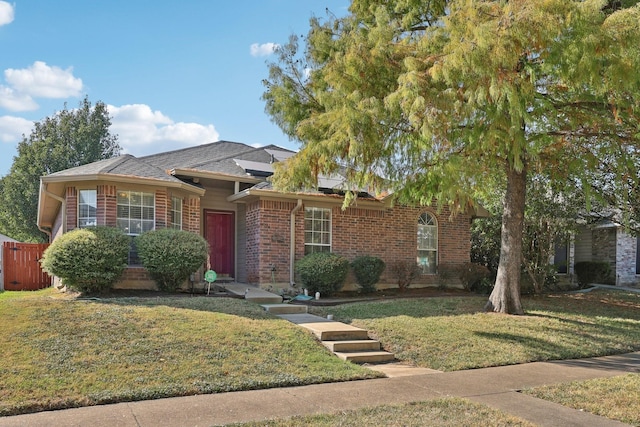 view of front of home with fence, a front lawn, and brick siding