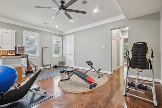 workout area featuring a ceiling fan, visible vents, and ornamental molding