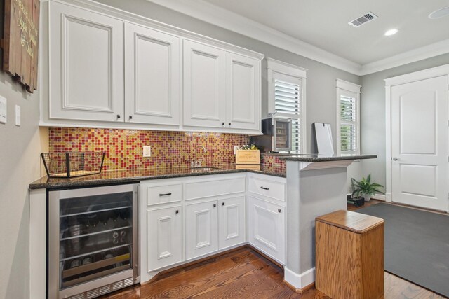 bar with wine cooler, visible vents, backsplash, and dark wood-style flooring