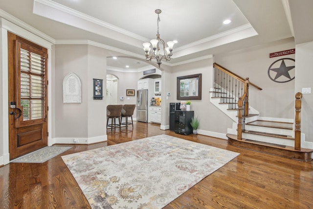 foyer entrance with stairway, crown molding, arched walkways, baseboards, and dark wood-style floors