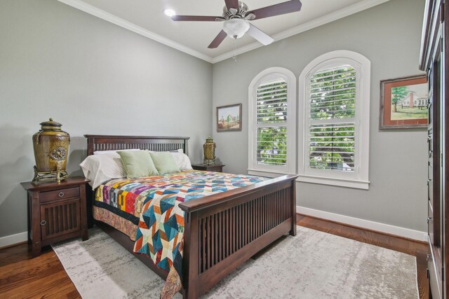 bedroom featuring a ceiling fan, baseboards, ornamental molding, and wood finished floors