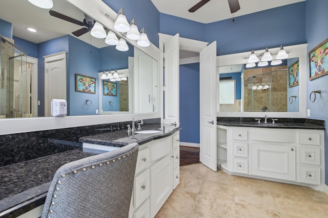 full bath with a ceiling fan, a sink, two vanities, and a stall shower