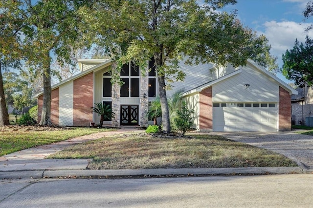 mid-century home with brick siding, aphalt driveway, and an attached garage