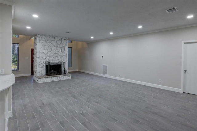 unfurnished living room with baseboards, visible vents, a fireplace, and recessed lighting