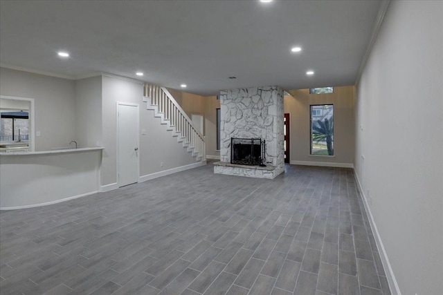 unfurnished living room with a healthy amount of sunlight, baseboards, recessed lighting, stairs, and ornamental molding