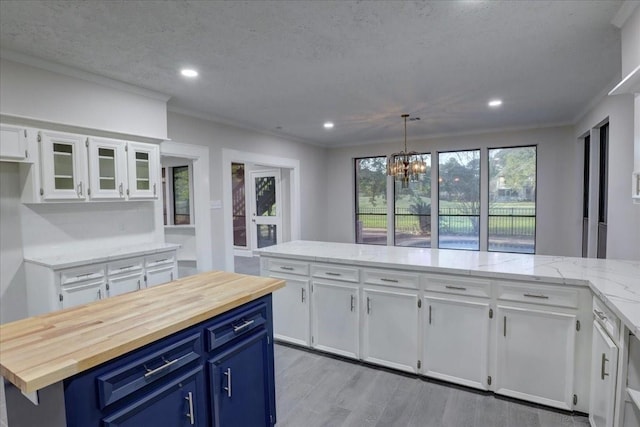 8407 Rebawood Dr, Humble, TX 77346 - kitchen featuring blue cabinetry, a chandelier, white cabinetry, butcher block countertops, and recessed lighting