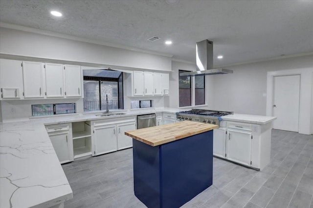 8407 Rebawood Dr, Humble, TX 77346 - kitchen featuring extractor fan, a sink, a peninsula, butcher block countertops, and white cabinets