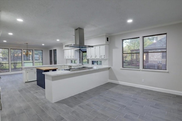 8407 Rebawood Dr, Humble, TX 77346 - kitchen with a peninsula, island exhaust hood, light countertops, recessed lighting, and white cabinets