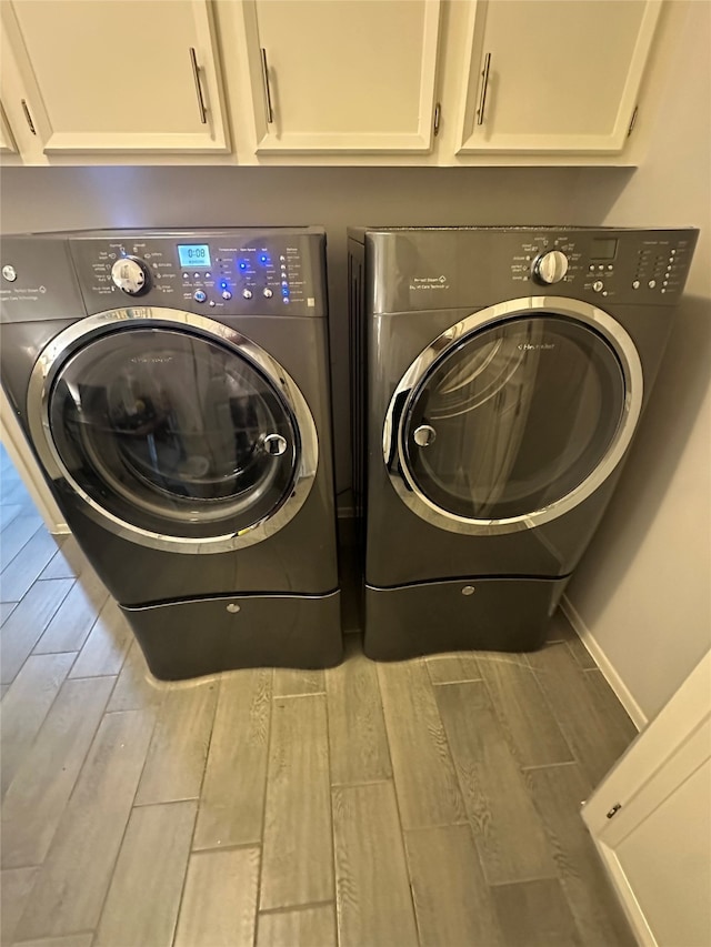 8407 Rebawood Dr, Humble, TX 77346 - laundry room with washer and dryer, wood finished floors, cabinet space, and baseboards