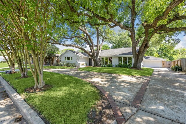 ranch-style home with fence, a front lawn, and a garage