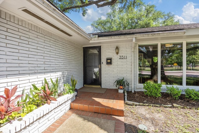 entrance to property featuring brick siding