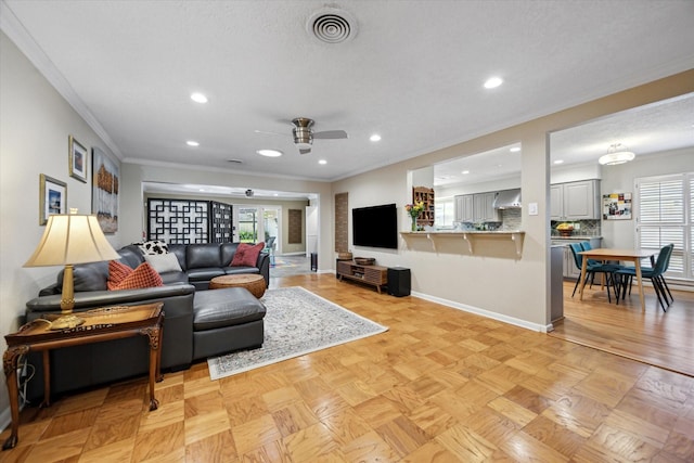 living room featuring ceiling fan, a healthy amount of sunlight, and visible vents