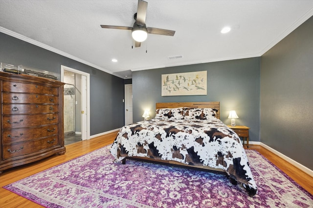 bedroom featuring wood finished floors, visible vents, baseboards, and ornamental molding