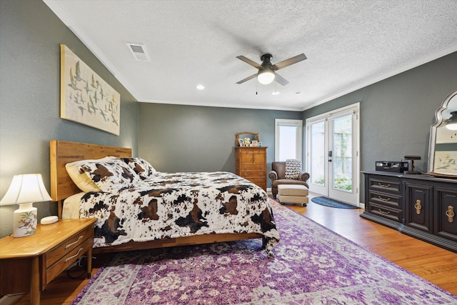 bedroom with crown molding, wood finished floors, access to exterior, and visible vents