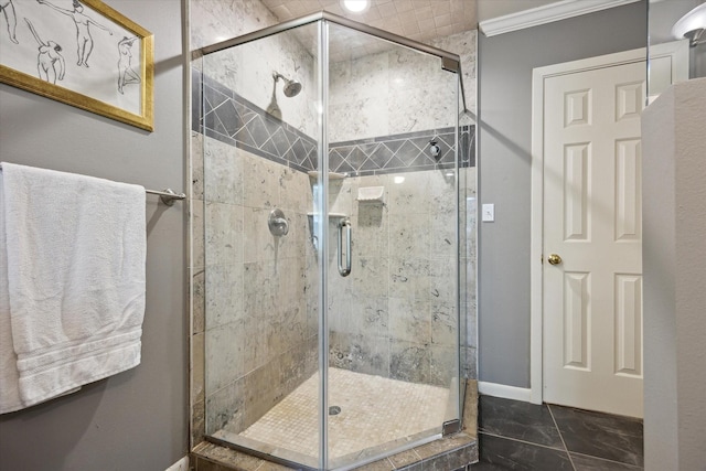 bathroom featuring baseboards, ornamental molding, and a stall shower
