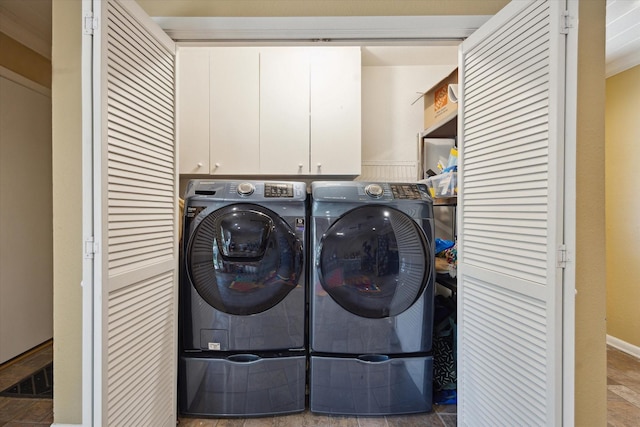 laundry area featuring cabinet space, independent washer and dryer, and stone finish floor