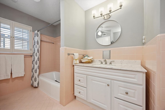 full bath with wainscoting, vanity, tile walls, shower / tub combo, and tile patterned flooring