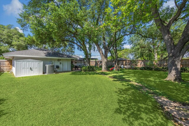 view of yard featuring an outdoor structure, cooling unit, a shed, and a fenced backyard