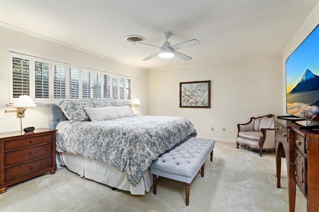 bedroom with carpet floors, crown molding, and ceiling fan