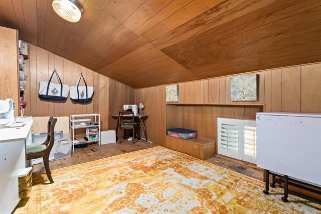 office area with wood finished floors, wooden ceiling, wooden walls, and vaulted ceiling
