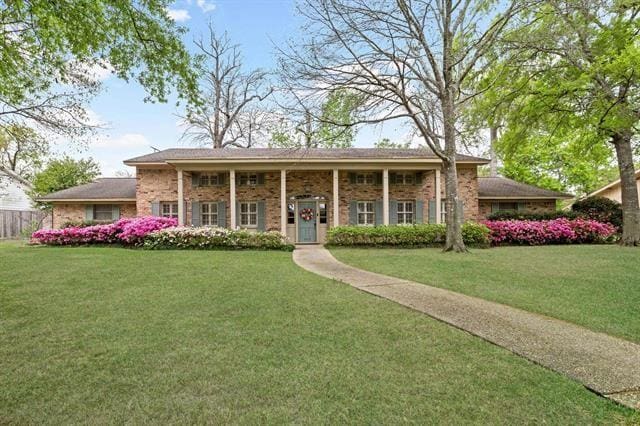 view of front of house featuring brick siding and a front yard