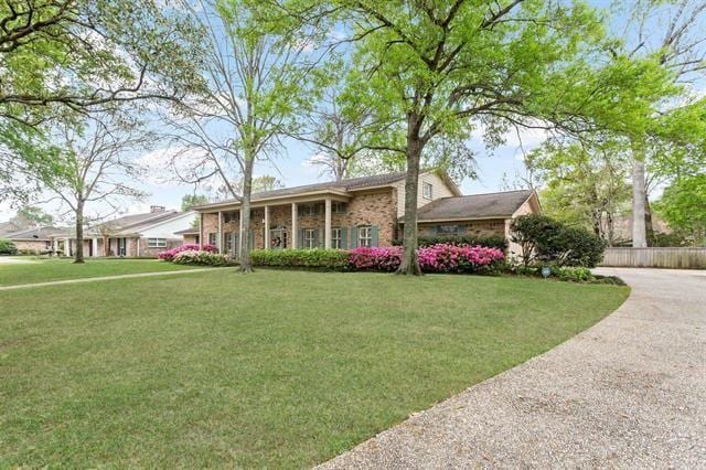 view of front facade featuring brick siding and a front lawn