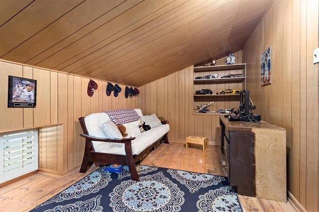 living area featuring vaulted ceiling, wood walls, wood ceiling, and wood finished floors