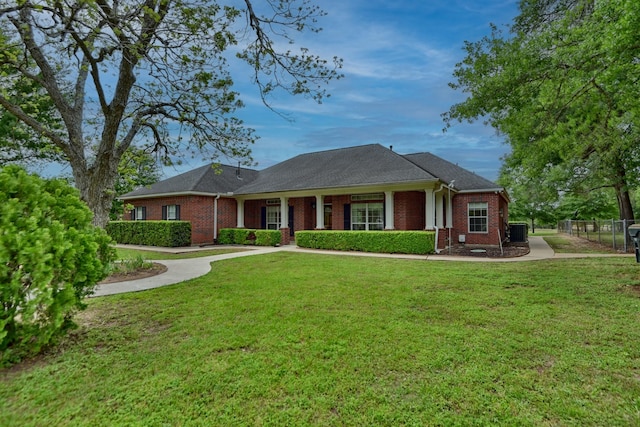 ranch-style home featuring brick siding, a front lawn, and fence