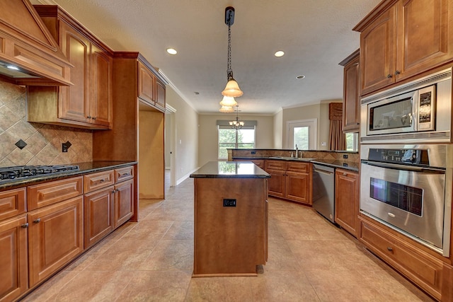 kitchen with a sink, decorative backsplash, a chandelier, appliances with stainless steel finishes, and custom exhaust hood