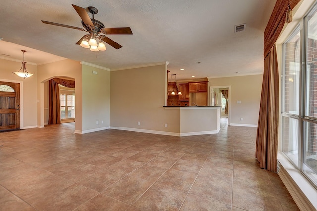 unfurnished living room with visible vents, a ceiling fan, ornamental molding, light tile patterned floors, and arched walkways