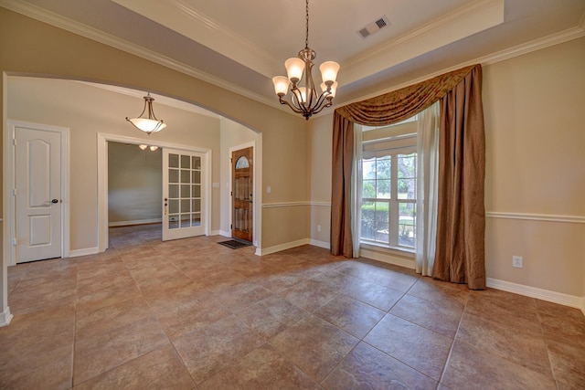 spare room with a raised ceiling, visible vents, ornamental molding, arched walkways, and a notable chandelier