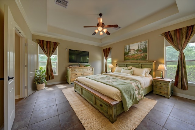 bedroom featuring baseboards, tile patterned flooring, a tray ceiling, and visible vents